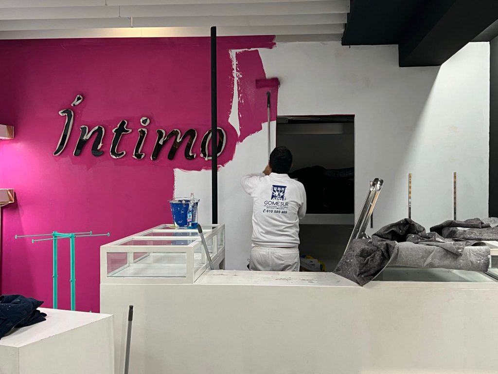 Operario Pintando tienda de intimo, cambiando color corporativo